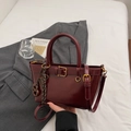 Elegante bolso bandolera color burdeos con acabado pulido y detalle de hebilla decorativa - Vino Tinto (Con Colgante)