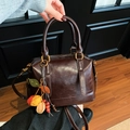 Deep brown vintage Boston handbag with glossy leather finish and colorful charm - With Charm / Brown