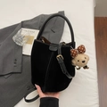 Sac seau noir mat avec surpiqûres contrastées et breloque ours sur literie blanche - Noir avec pendentif