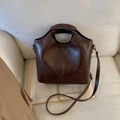 Detailed view of dark brown vintage leather bucket bag texture and fine vertical stitching - No Pendant / Brown