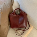 Detail of burgundy leather bucket bag with integrated circular handle and gold hardware - No Pendant / Burgundy