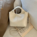 Chic cream bucket bag with cutout handle on a sofa, featuring gold metal hardware - No Pendant / White