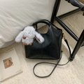 Detail of black faux leather bucket bag with cute white plush rabbit charm accessory - With Charm / Black