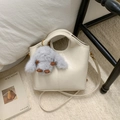 Detail of cream white leather bucket bag with vertical stitching and plush rabbit charm - With Charm / White