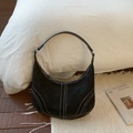 Detail van zwarte lederen hobo tas met contrast wit stiksel en metalen gesp sluiting - Zwart