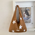 Detail der braunen Hobo-Tasche mit Stern-Applikationen und kleinem Webetikett an der Wand - Braun