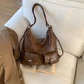 Vintage brown leather tote bag with double front buckle pockets displayed on a white sofa - No Pendant / Brown