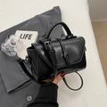 Bolso bandolera negro minimalista brillante con cierre giratorio circular metálico - Negro