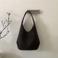 Macro shot of dark brown hobo bag featuring vertical stitching and soft suede texture - Brown