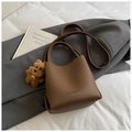 Brown lychee leather bucket bag with top handle, adjustable strap, and plush dog charm - Brown with Pendant