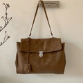 Detalle de un bolso tote vintage marrón oscuro con textura de ante y hebilla metal - Marrón