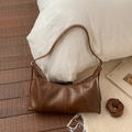 Detail of retro brown underarm bag showing stitched patchwork and silver hardware - Brown
