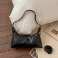 Detail view of black minimalist hobo bag with vertical stitching and adjustable shoulder strap - Black