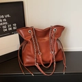 Dettaglio borsa vintage caramello con tracolla a catena e logo in rilievo - Rosso
