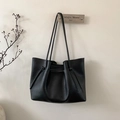 Detail of minimalist black leather tote bag with drawstring knots and slender shoulder strap - Black