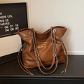 Dettaglio borsa tote vintage in pelle marrone con tracolla a catena e logo moda - Marrone