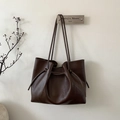 Detailed close-up of dark brown tote bag featuring elegant pleated drawstring design - Brown