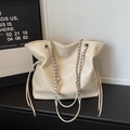 Dettaglio della borsa tote in pelle color crema con catene e chiusura a coulisse - Bianco Sporco