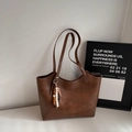 Dettaglio della borsa tote marrone vintage con texture e ciondolo in perline di legno - Marrone