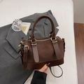 Retro deep brown woven Boston bag with top handles and adjustable strap in lifestyle setting - Coffee No Charm