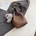 Bolso tipo cubo de cuero marrón con cierre de giro plateado y pompón de peluche - Marrón con colgante