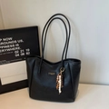 Detailansicht der schwarzen Leder-Shopper-Tasche mit Holzperlenanhänger und Logo-Patch - Schwarz