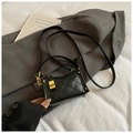 Detailed macro view of black quilted leather bag with elegant golden turn-lock closure - Black