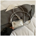 Dettaglio di mini borsa argento metallizzato con cuciture su giacca grigia - Argento