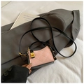 Detail of pink and black quilted crossbody bag with gold twist lock and leather handle - Pink