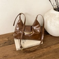 Detail of vintage brown oily leather bag featuring gold metallic hardware and texture - Brown