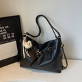 Detail of black PU leather tote bag featuring gold hardware and a cute white teddy charm - Black