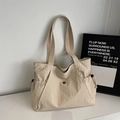 Close-up of beige tote bag material showing fabric texture and side drawstring pocket - Off White