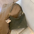 Detalle de bolso de ante verde oscuro en forma de media luna con herrajes dorados y colgante de perro - Verde Oliva