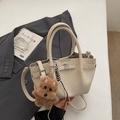 Borsa a secchiello beige minimalista in pelle litchi con ciondolo a cane di peluche marrone - Con Ciondolo / Bianco