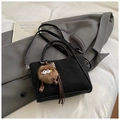 Elegante schwarze Wildlederhandtasche mit braunem Pelzanhänger und Umhängeriemen im Alltag - Schwarz mit Anhänger