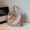 Detailed view of pink tote bag featuring a gold buckle and cute teddy bear charm accessory - Pink