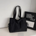 Detail of minimalist black tote bag with side drawstrings and premium metal logo detail - Black