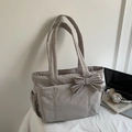 Detailed view of dark grey tote bag featuring a large bow and side elastic pocket - Gray