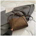 Detail of a dark brown bucket bag with adjustable strap on a grey trench coat background - Standard Type / Brown