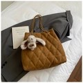 Close-up of quilted dark brown tote bag with gold chain strap and plush rabbit charm - With Charm / Brown
