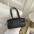 Classic black leather tote bag with decorative drawstrings and golden hardware on sofa - Black without Pendant