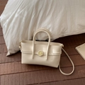 Close-up of off-white lychee grain leather handbag with gold twist lock and dual handles - Off White