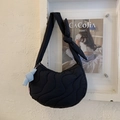 Detail of black quilted crescent bag featuring knotted strap and cute plush charm - Black (With Pendant)