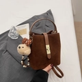 Detail of retro brown suede bucket bag with gold metal lock and cute plush bear charm - With Charm / Brown