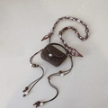 Détail macro du mini sac en daim marron foncé avec foulard en soie et perles en bois - Marron