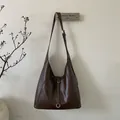 Vue détaillée du sac cabas café en similicuir brillant avec des boucles argentées - Marron
