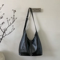 Gros plan détaillé d'un sac cabas minimaliste en cuir noir suspendu à un crochet - Noir