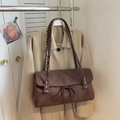Detail of dark coffee suede tote bag featuring braided strap and silver rivets accents - Brown