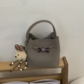 Gros plan détaillé du sac seau taupe avec fermoir nœud en métal et breloque ourson - Avec Pendentif / Gris