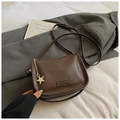 Detail of dark brown lychee grain leather bag featuring a gold star charm and brand logo - Coffee With Pendant